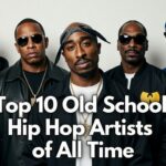 Group portrait of iconic old school hip hop legends standing together against a plain white wall: Eminem, Dr. Dre, Tupac Shakur, Snoop Dogg, and members of Wu-Tang Clan (including RZA, Method Man, and others), all wearing classic 90s rap fashion with gold chains, leather jackets, snapbacks, bandanas, and sunglasses. Bold white text overlay reads "Top 10 Old School Hip Hop Artists of All Time